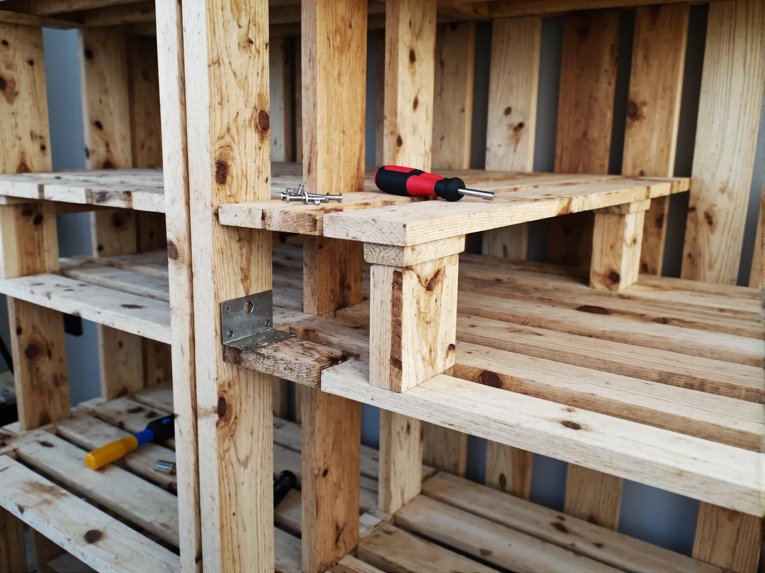 Zbliżenie na detale i półki regału wykonanego samodzielnie z palet.